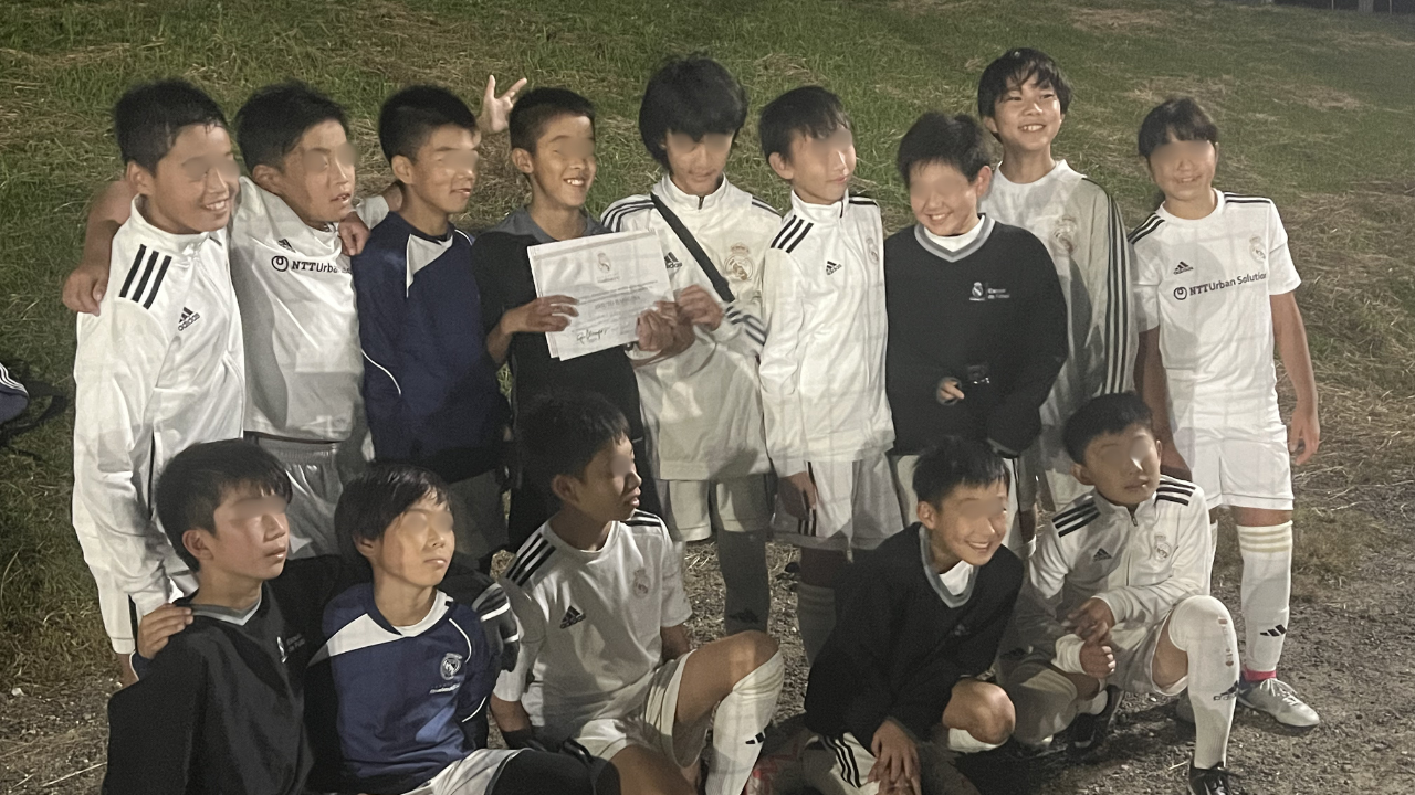 少年サッカーの仲間たちと笑顔で記念撮影する子どもたち